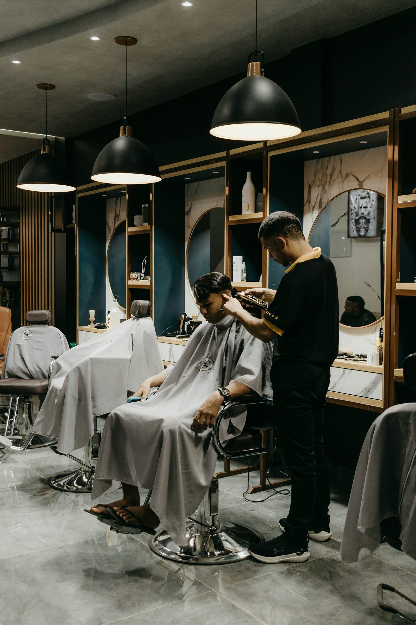 Barber cutting a men's hairstyle in a modern barbershop
