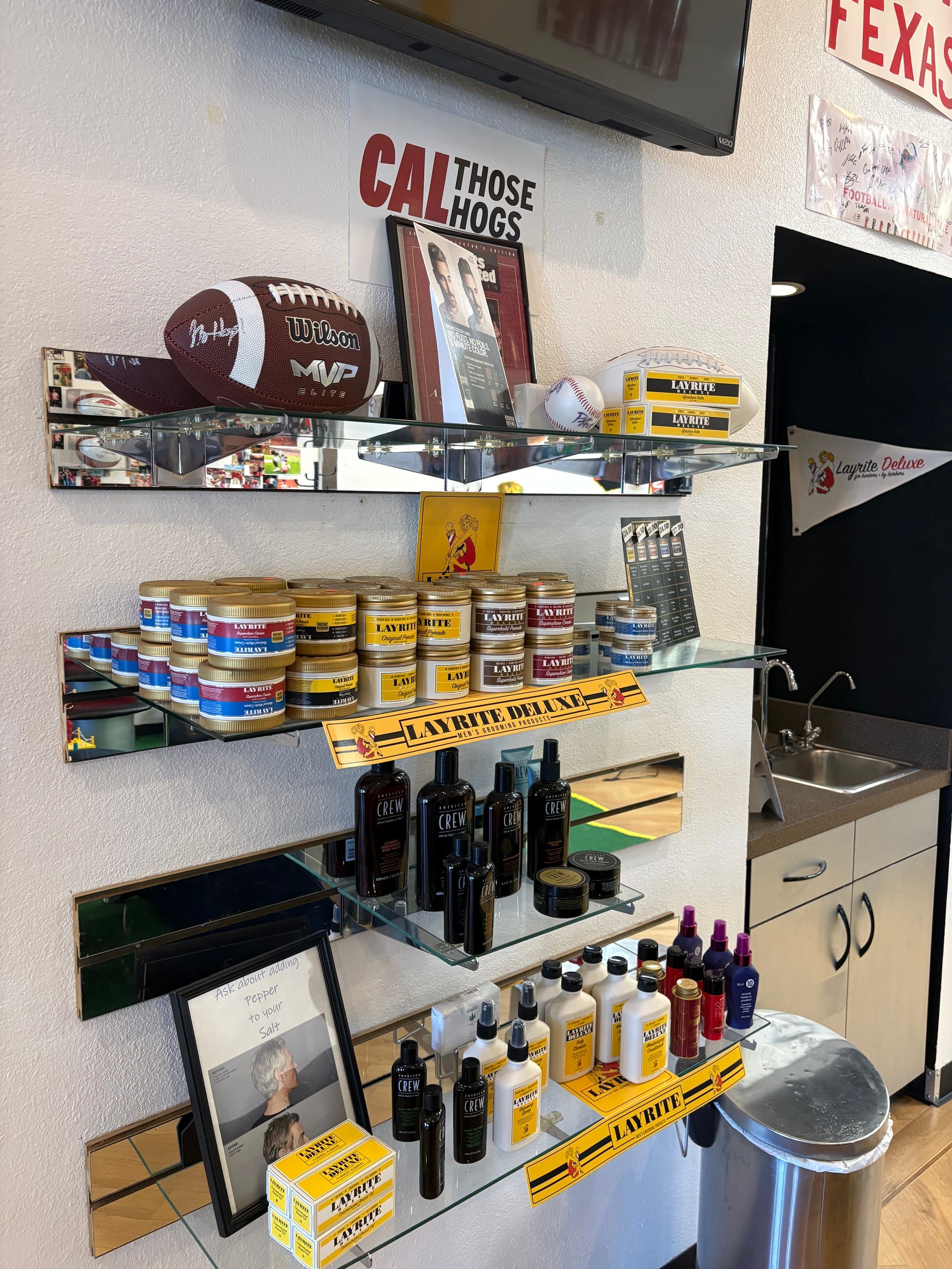 Men's grooming products and sports memorabilia inside Fantasy Sports Cuts in Fayetteville AR